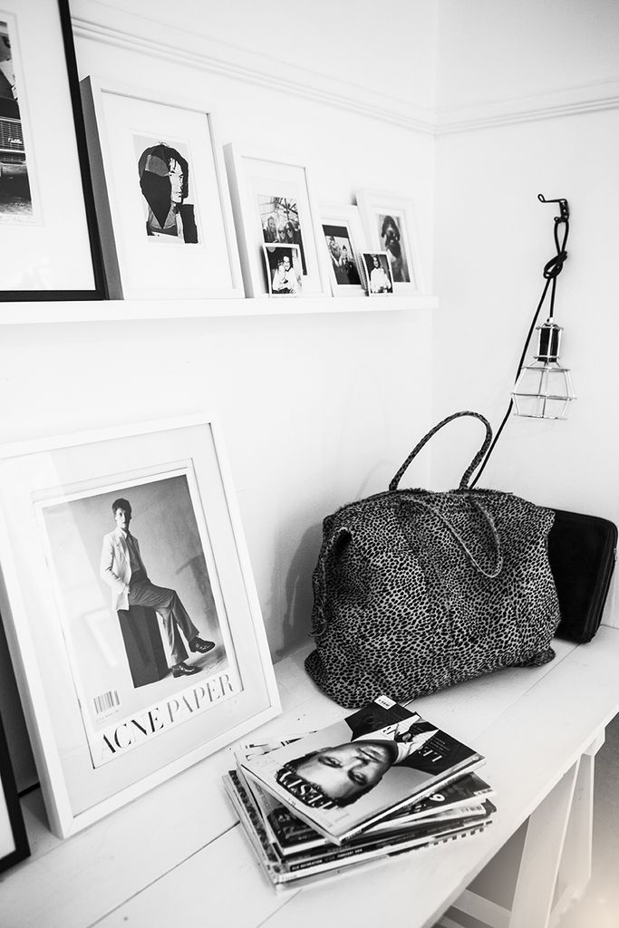Black and white interior photo with pictures and grey bag